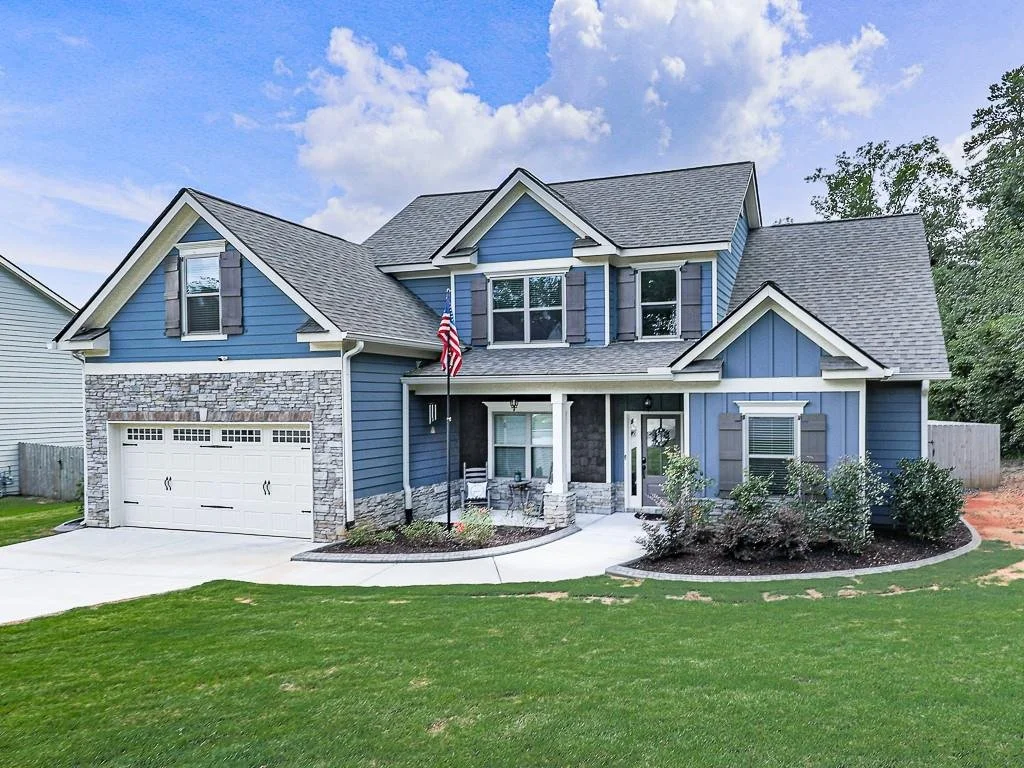 Front exterior of a craftsman home on a cul-de-sac in Ball Ground, Georgia, with stone accents and a covered porch