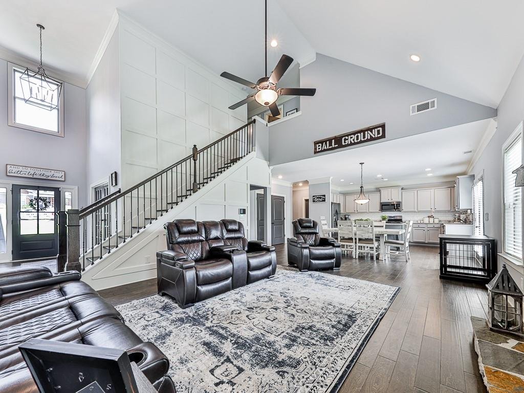 Open living room with a floor-to-ceiling stacked stone fireplace inside the Ball Ground home