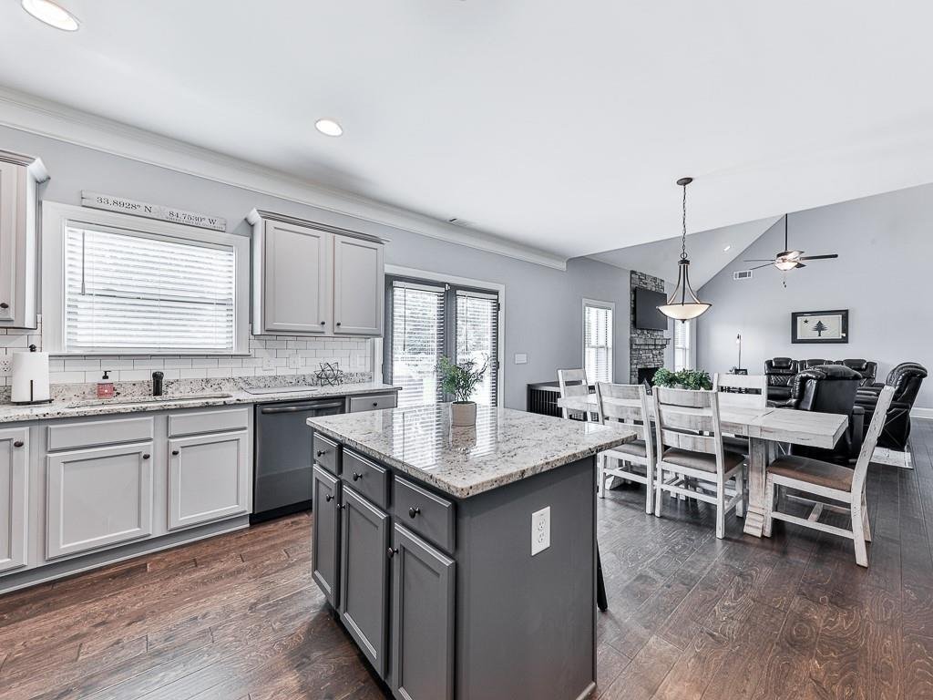 Chef's kitchen with island and adjoining living space in the Ball Ground home